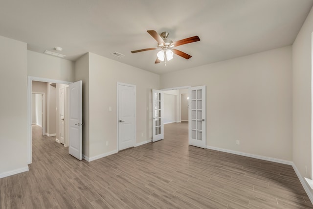 unfurnished room featuring light wood-type flooring, ceiling fan, and french doors