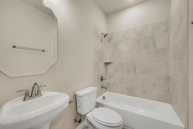 full bathroom featuring sink, tiled shower / bath combo, and toilet