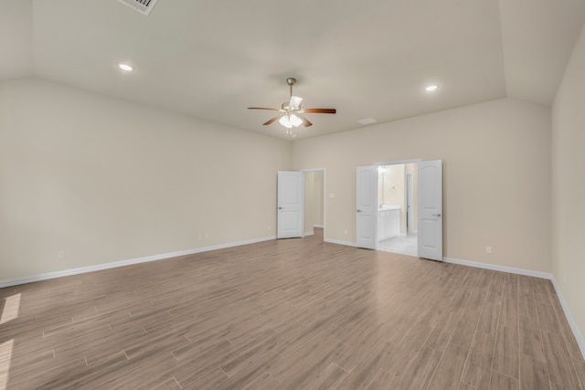 spare room featuring light hardwood / wood-style flooring, lofted ceiling, and ceiling fan