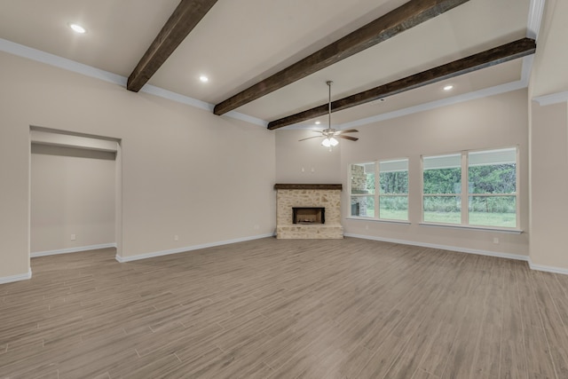 unfurnished living room with light hardwood / wood-style floors, ceiling fan, beamed ceiling, and a fireplace