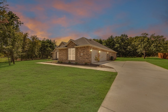 property exterior at dusk featuring a garage and a yard