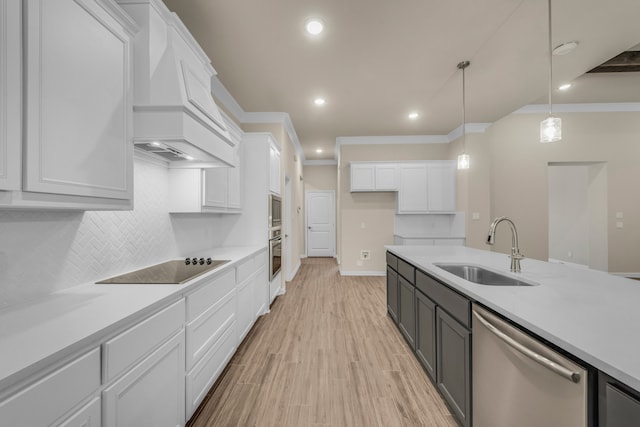 kitchen featuring appliances with stainless steel finishes, hanging light fixtures, white cabinetry, and sink