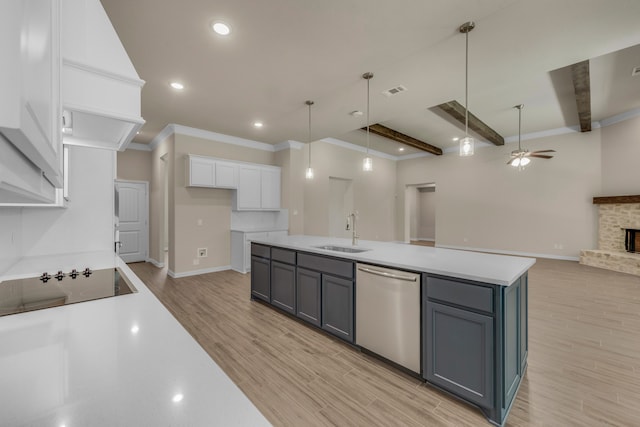 kitchen featuring ceiling fan, sink, a stone fireplace, white cabinetry, and dishwasher