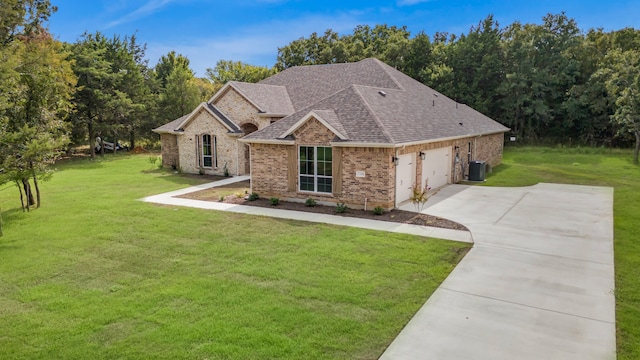 view of front of home featuring central AC unit, a front yard, and a garage