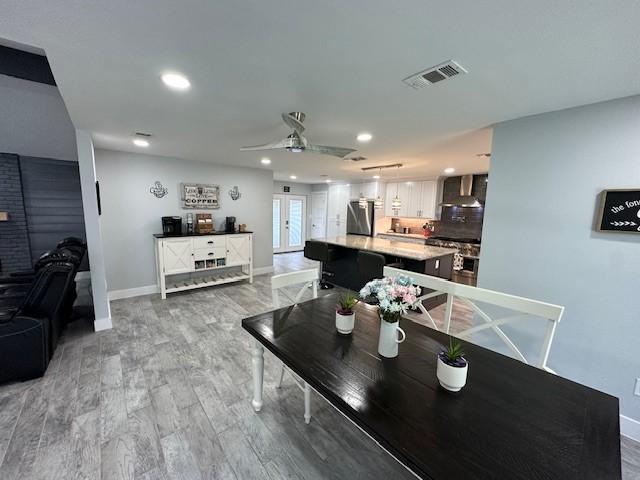 dining room featuring ceiling fan, hardwood / wood-style floors, and french doors