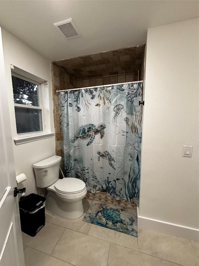 bathroom featuring tile patterned floors, toilet, and a shower with curtain