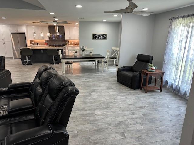 living room featuring light wood-type flooring and ceiling fan