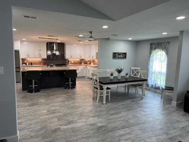 dining space with vaulted ceiling and ceiling fan