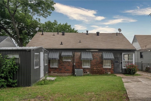 back of house featuring a yard and central AC unit