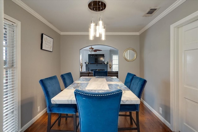 dining space with ornamental molding and dark hardwood / wood-style flooring