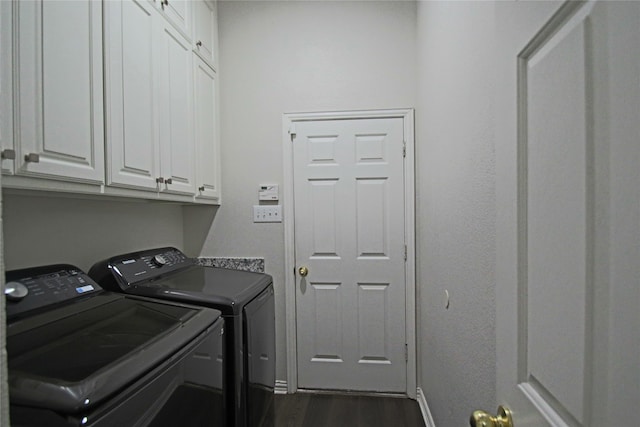 laundry room featuring cabinets, washing machine and dryer, and dark hardwood / wood-style flooring