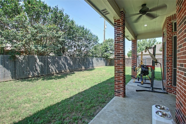 view of yard with ceiling fan and a patio area