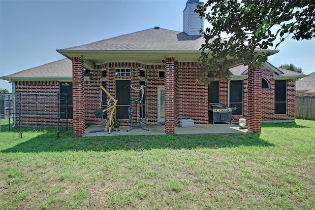 back of house featuring a patio and a yard