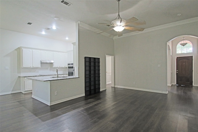 kitchen with ceiling fan, dark wood-type flooring, ornamental molding, and white cabinetry