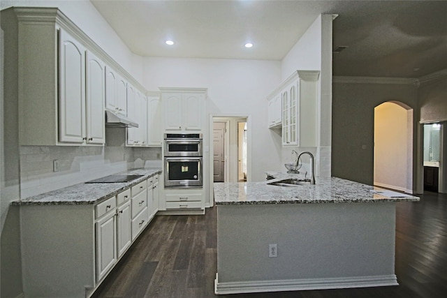 kitchen featuring decorative backsplash, dark hardwood / wood-style floors, white cabinetry, double oven, and sink