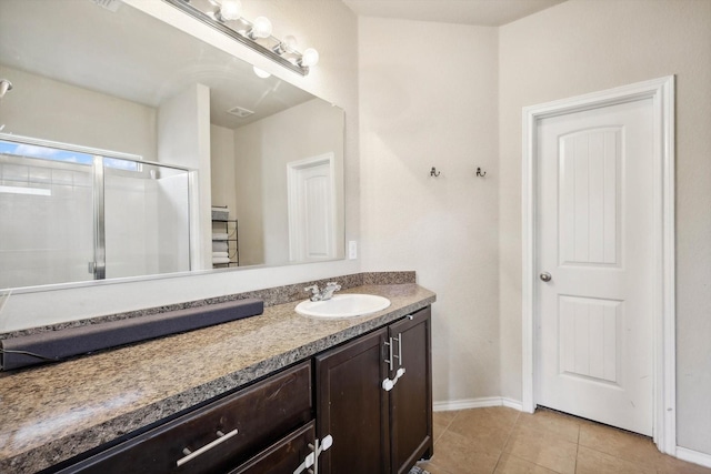 bathroom featuring vanity, a shower with shower door, and tile patterned floors