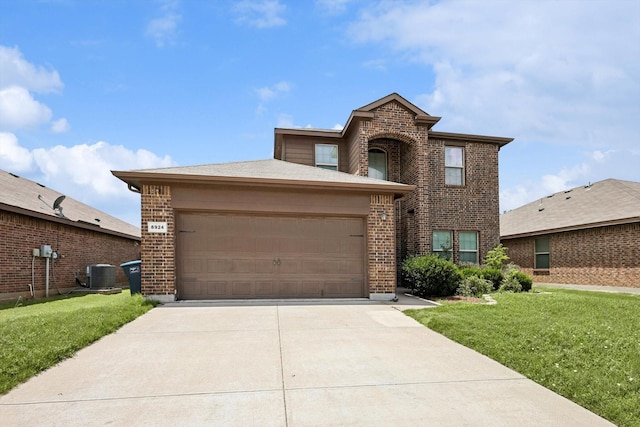 view of front of property featuring cooling unit, a garage, and a front lawn