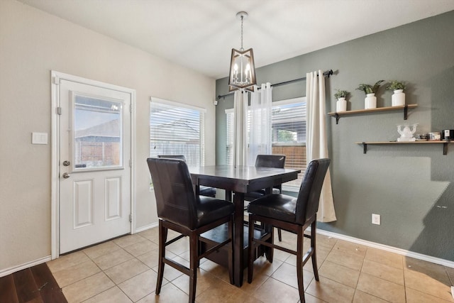 dining space with an inviting chandelier and light tile patterned floors