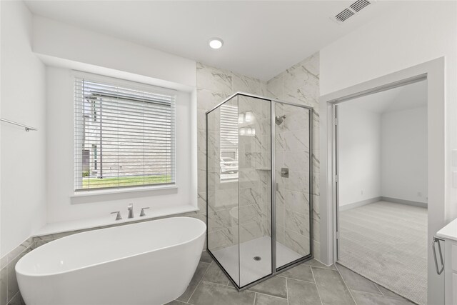 bathroom featuring tile patterned flooring and plus walk in shower