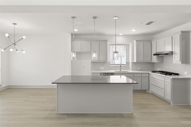 kitchen featuring light hardwood / wood-style floors, appliances with stainless steel finishes, tasteful backsplash, and a kitchen island