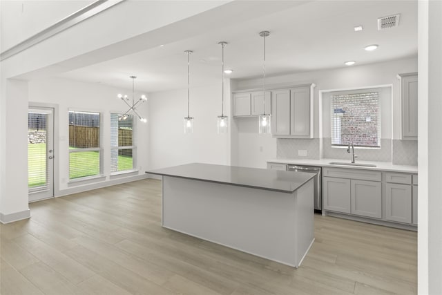 kitchen featuring a center island, light hardwood / wood-style flooring, tasteful backsplash, and a wealth of natural light