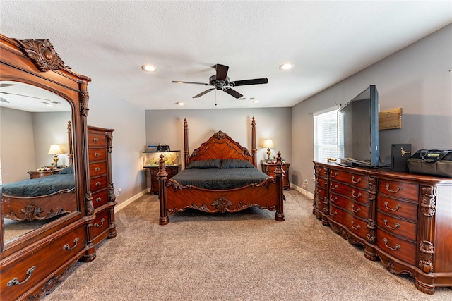 bedroom featuring ceiling fan, light colored carpet, and a textured ceiling