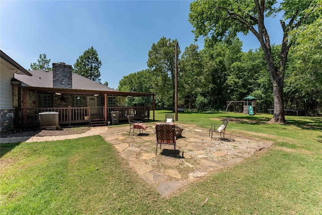 view of yard featuring a playground, an outdoor fire pit, and a patio