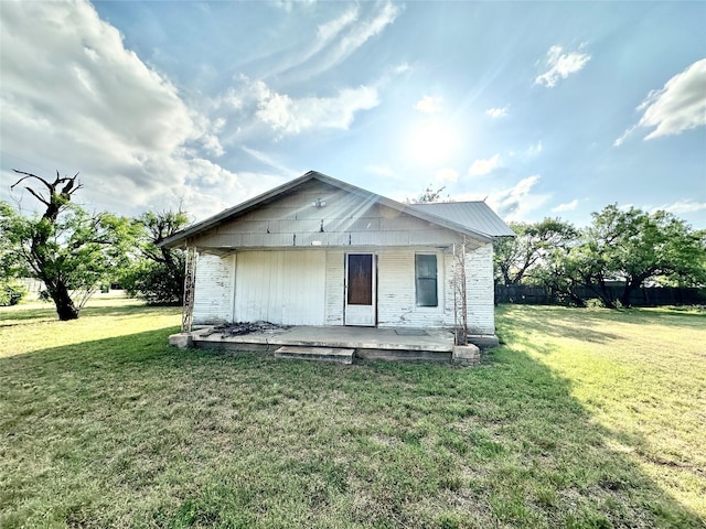 rear view of house featuring a yard and a patio area