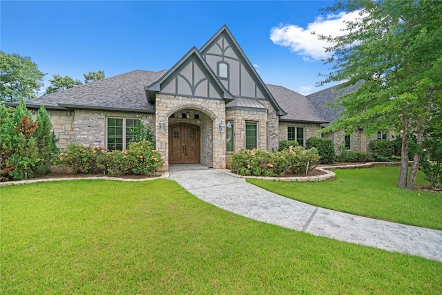 english style home featuring a front yard