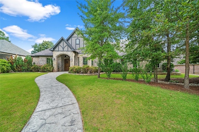 tudor home featuring a front lawn