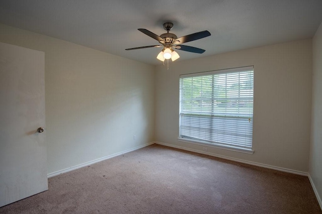 carpeted spare room with ceiling fan