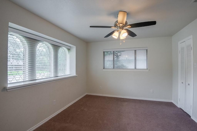 unfurnished bedroom featuring a closet, ceiling fan, and dark colored carpet