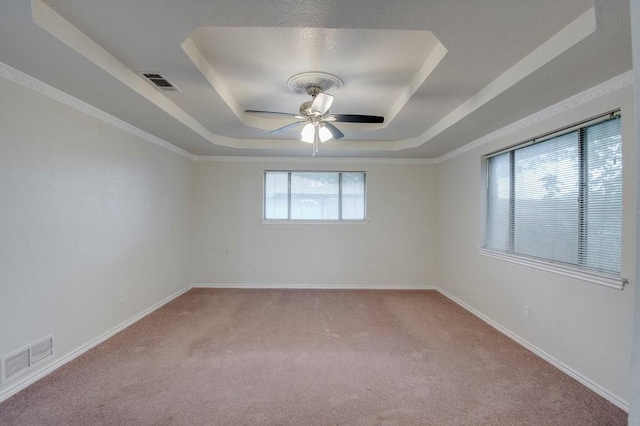 carpeted empty room featuring ceiling fan and a tray ceiling