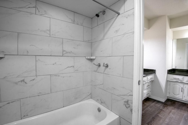 bathroom featuring hardwood / wood-style flooring, tiled shower / bath combo, and vanity