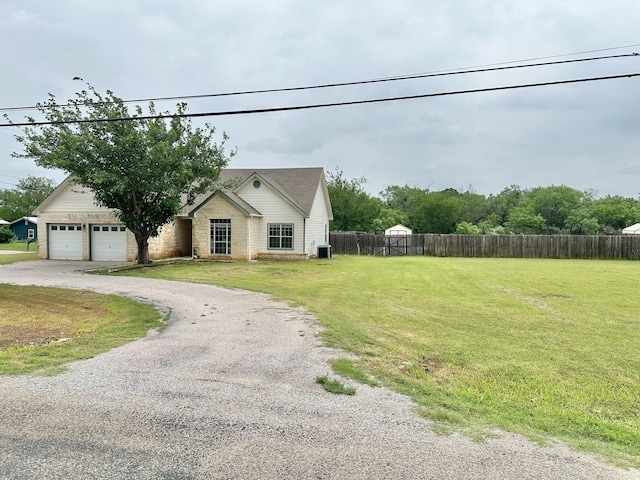 view of front of house featuring central AC, a front lawn, and a garage