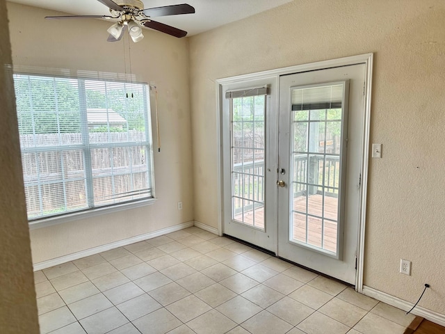 doorway with light tile patterned floors, ceiling fan, and french doors