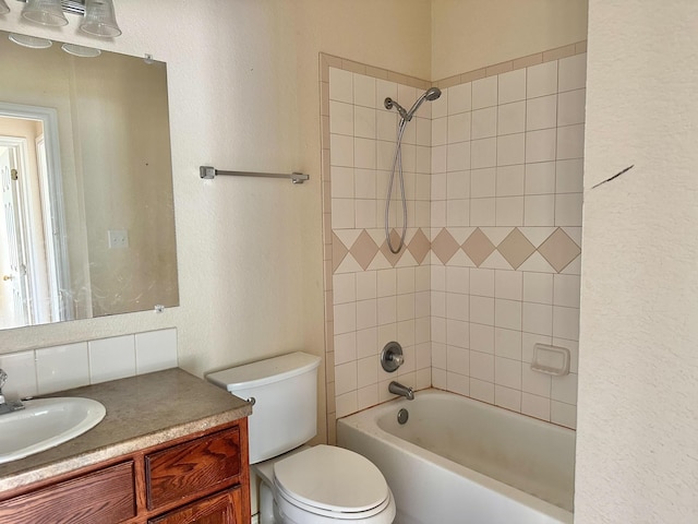 full bathroom featuring tiled shower / bath combo, vanity, and toilet