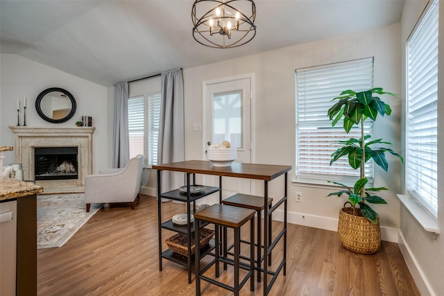 dining room featuring hardwood / wood-style flooring, a premium fireplace, and a chandelier