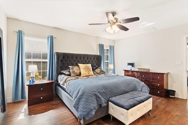 bedroom featuring ceiling fan, dark hardwood / wood-style flooring, and multiple windows