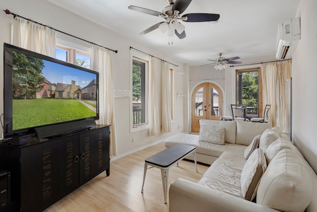 living room with french doors, ceiling fan, light wood-type flooring, and an AC wall unit