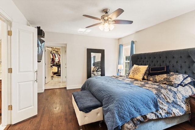 bedroom with a closet, a spacious closet, ceiling fan, and dark wood-type flooring