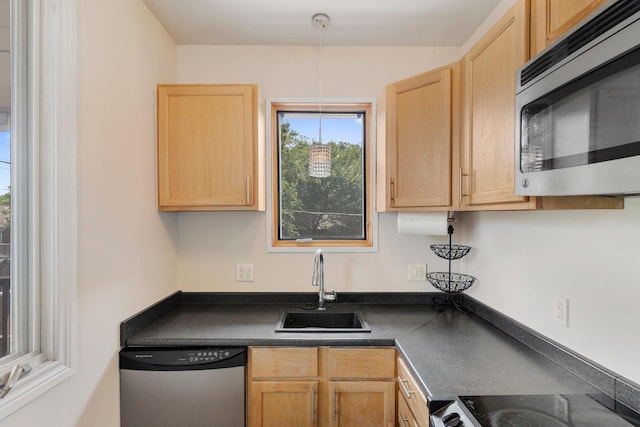 kitchen with appliances with stainless steel finishes, light brown cabinetry, and sink