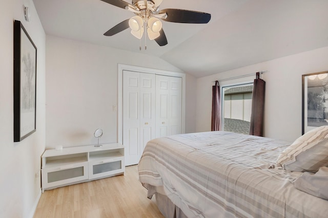 bedroom featuring ceiling fan, light hardwood / wood-style floors, lofted ceiling, and a closet