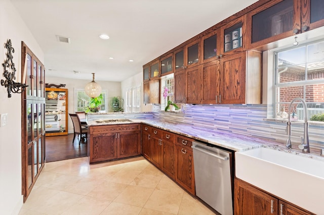 kitchen featuring hanging light fixtures, sink, light stone countertops, appliances with stainless steel finishes, and kitchen peninsula