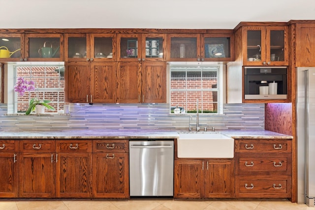 kitchen with backsplash, sink, light tile patterned floors, light stone counters, and stainless steel appliances