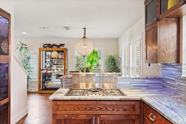 kitchen featuring pendant lighting, an inviting chandelier, decorative backsplash, dark hardwood / wood-style floors, and stainless steel gas cooktop