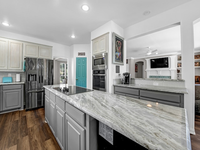 kitchen featuring backsplash, dark hardwood / wood-style floors, gray cabinetry, and stainless steel appliances