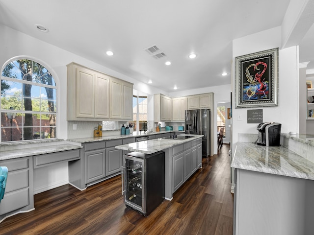 kitchen with gray cabinetry, a kitchen island, dark wood-type flooring, and wine cooler