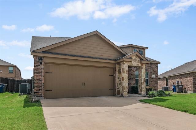 view of front of home featuring a garage, a front yard, and central AC unit