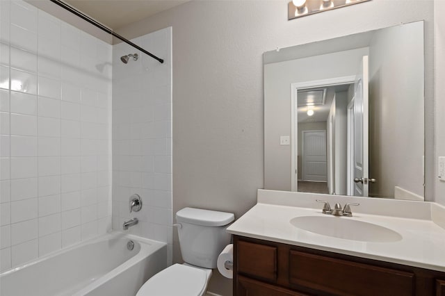 full bathroom with vanity, tiled shower / bath combo, and toilet